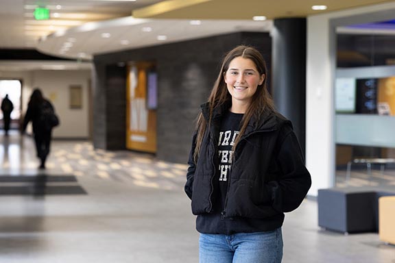 A PNW student stands in the Mane Zone on campus