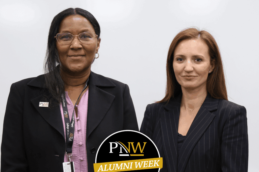 Two well dressed women smiling in front of a whiteboard