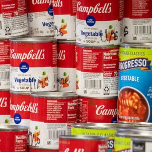 Campbell's and Progresso vegetable cans stacked on a shelf.