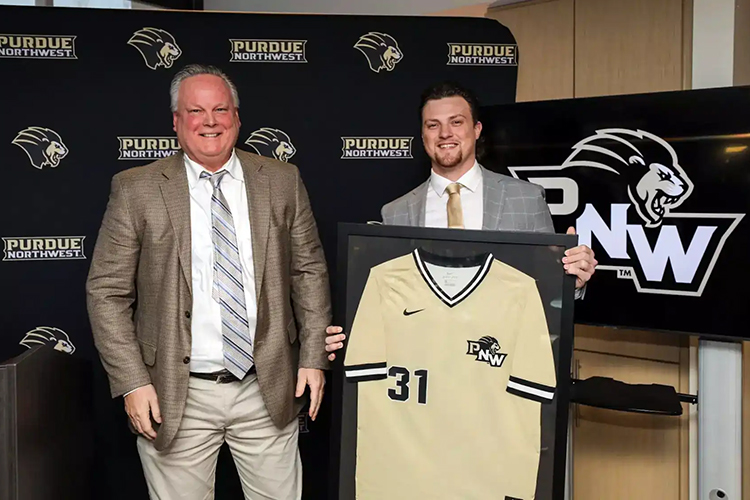 Former PNW pitcher Chad Patrick poses with his framed jersey at his jersey-retirement ceremony.