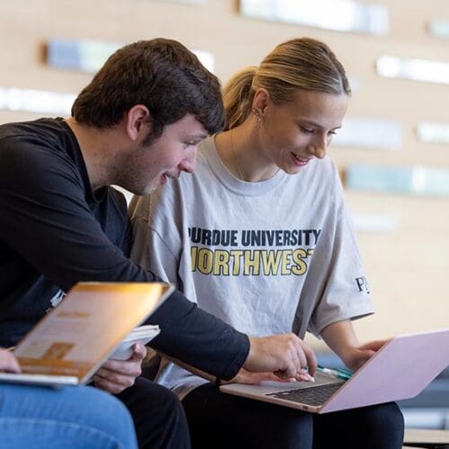 PNW students collaborate on a laptop.