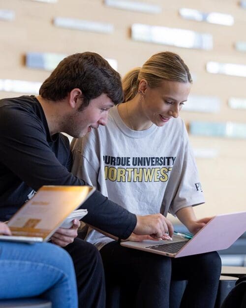 PNW students collaborate on a laptop.