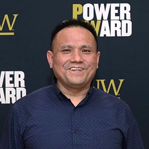 Michael Tu before a PNW/Power Onward banner.