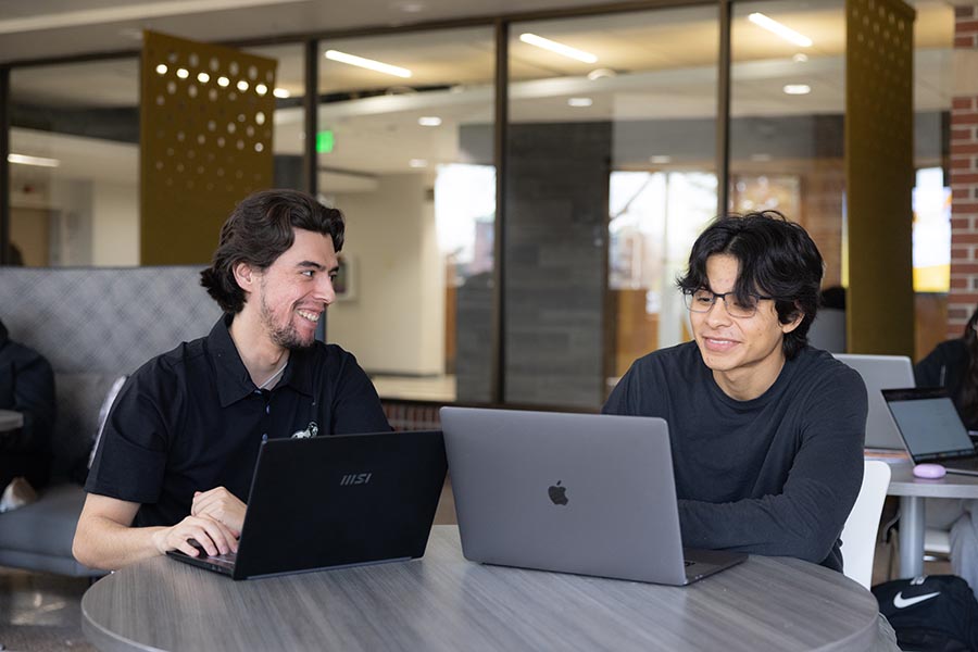 Two PNW students working on their laptops in the CLO Student Lounge.