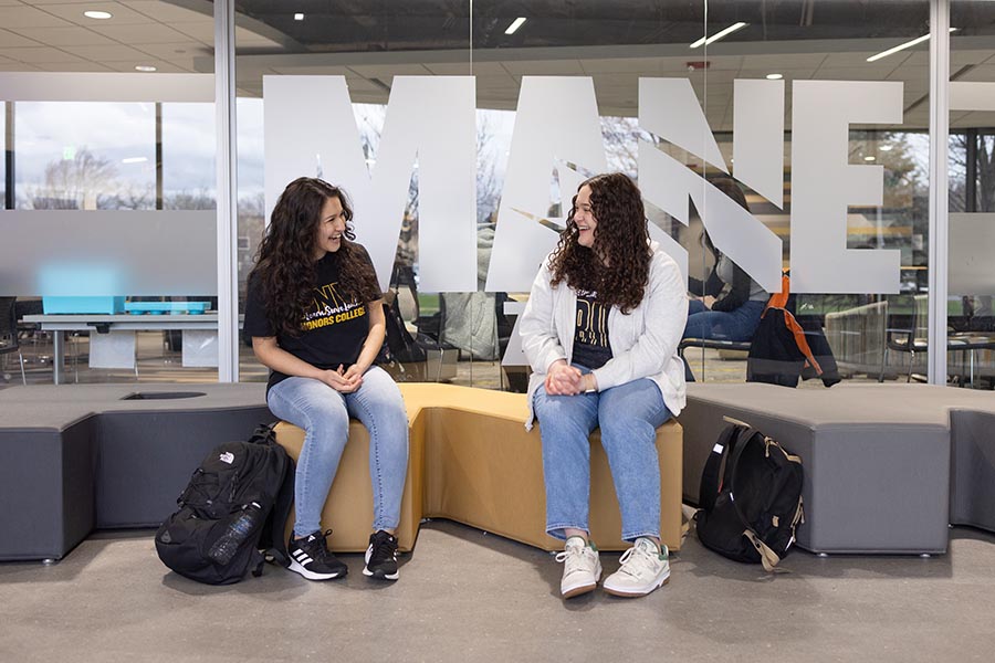 Two students in the Mane Zone while talking and laughing