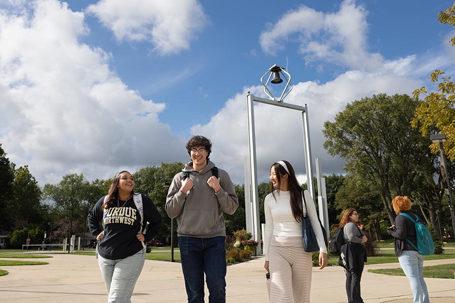 PNW students talking in front of the bell tower on the Hammond Campus. 