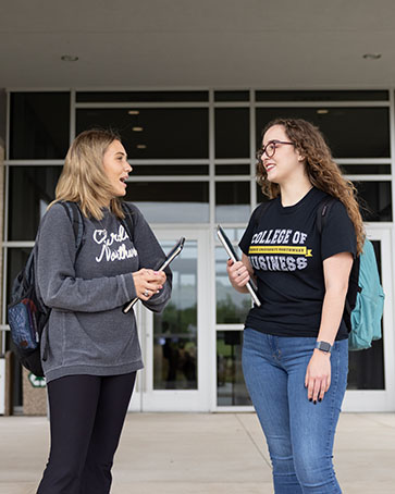 Two students stand outside a building on the PNW Westville campus.