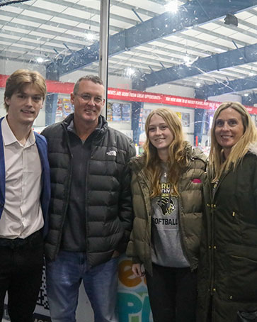 A family poses together at a PNW hockey game.