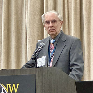 David Durkee stands at a PNW branded podium.