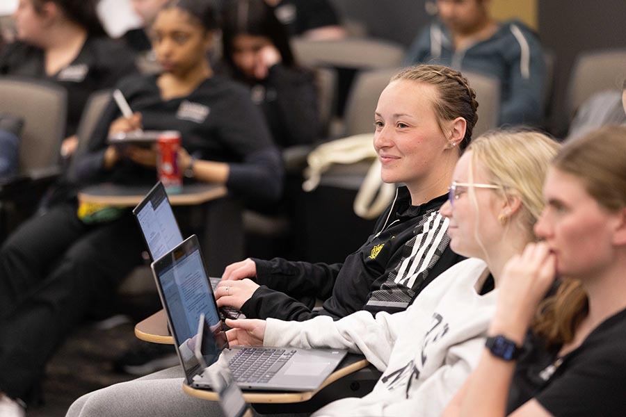 PNW students sitting in chairs while on their laptops