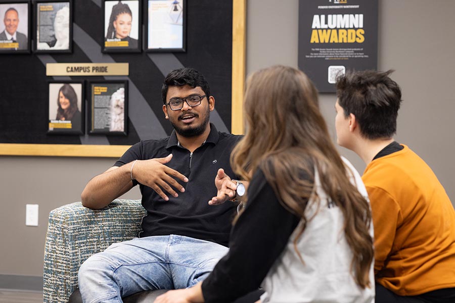 Three PNW students talking to one another on campus