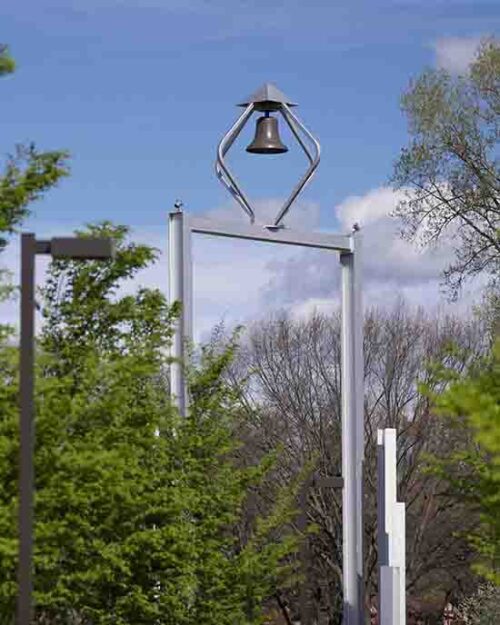 The PNW bell tower surrounded by green trees.