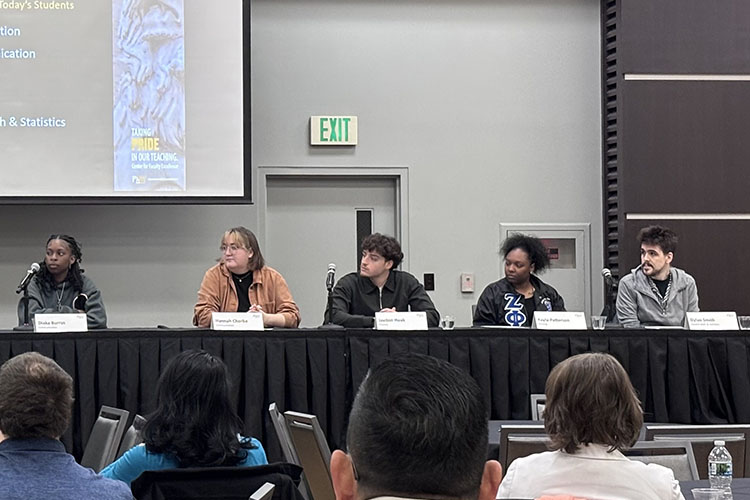 Five student panelists sit on a stage. 