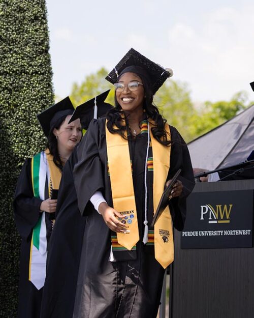 A PNW graduate walks across the stage at Commencement
