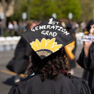 A decorated graduation cap. The cap reads - 1st Generation Grad - with a sunflower drawn under.