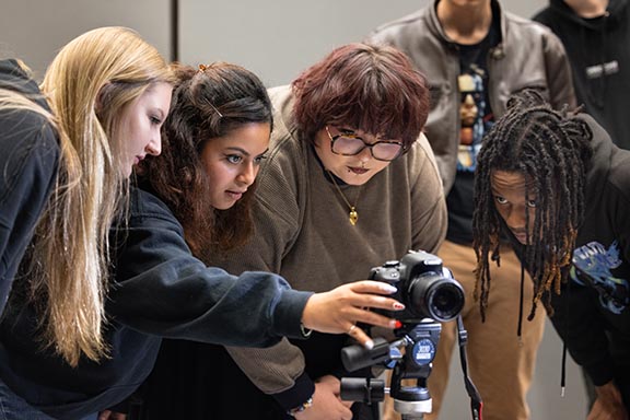PNW students looking at a camera while talking together