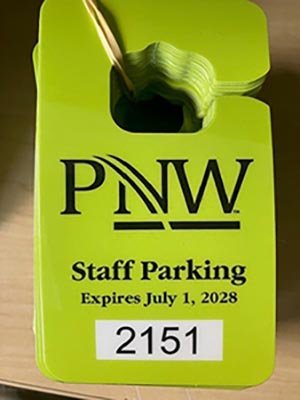 A green PNW parking hang tag with text: PNW Staff parking expires July 1, 2028.