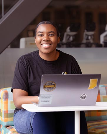 A PNW student works at a laptop