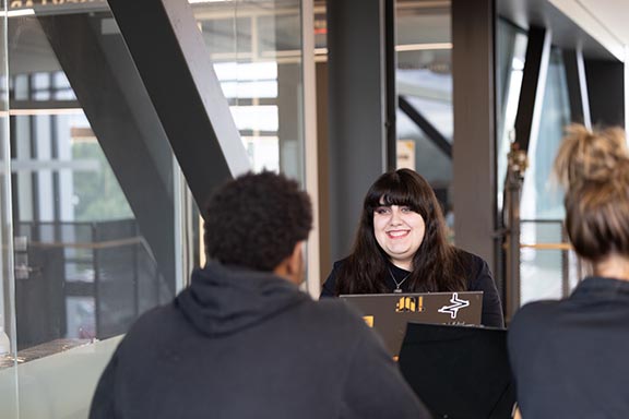 Two PNW students talking to one another at a table in the NILS building