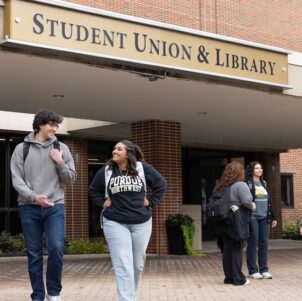 PNW students outdoors in front of the Student Union & Library building.