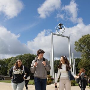 PNW students walk in front of the Bell Tower.