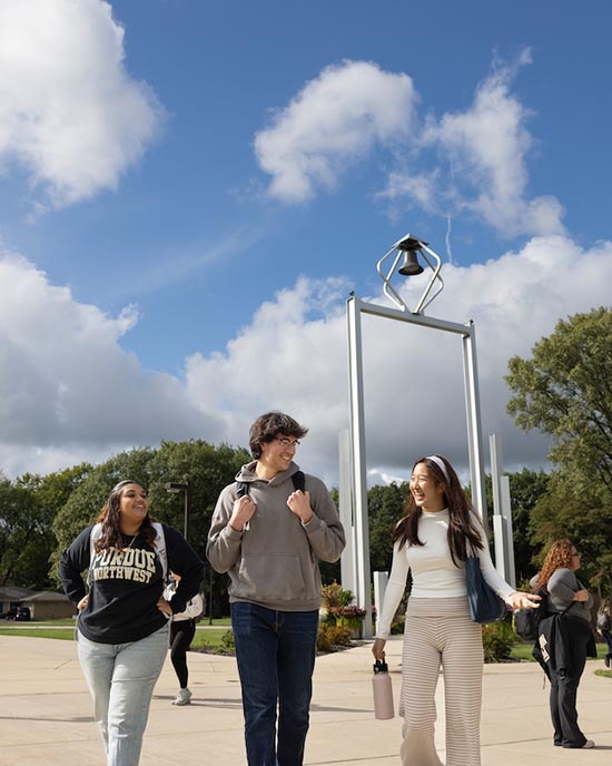 PNW students walk in front of the Bell Tower.