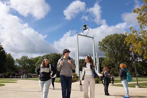 PNW students walk in front of the Bell Tower.