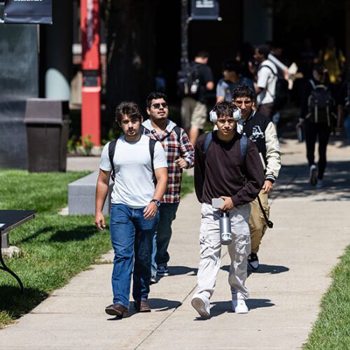 Students walk down a sidewalk on the first day of classes.