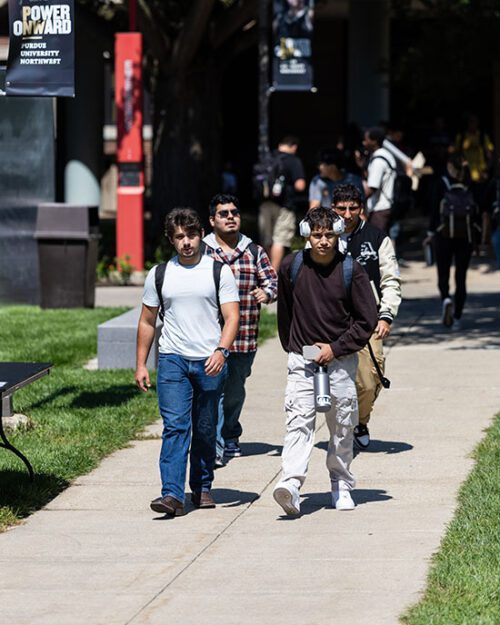 Students walk down a sidewalk on the first day of classes.