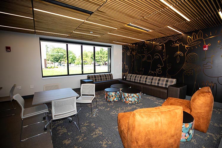 A shared space in Calumet Hall featuring a mural, couches and tables.