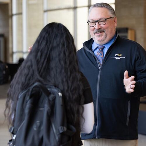 PNW Chancellor Holford talks with a student