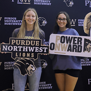 Two students pose with photo props during a welcome rally event.