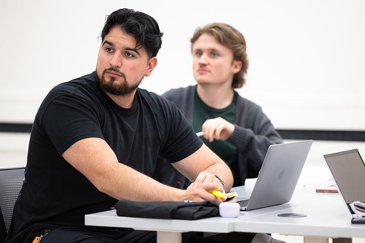 Two PNW students looking at the professor while in class