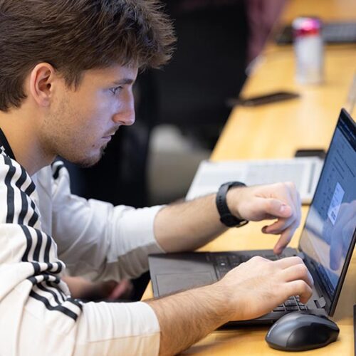 PNW student typing on his laptop