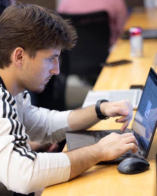 PNW student typing on his laptop