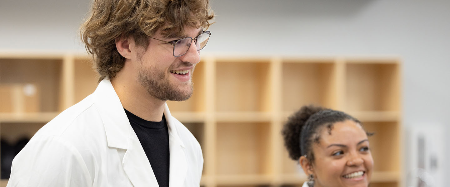 Two students stand in a microbiology lab