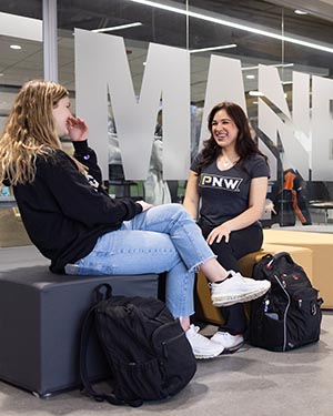 Two PNW students talking with one another in the Mane Zone