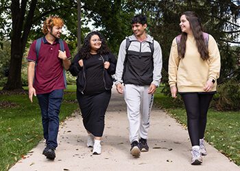Four students walk together outdoors