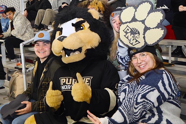 PNW mascot Leo sits with fans in the stands.