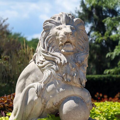 A lion sculpture outdoors amidst greenery at Purdue University Northwest.