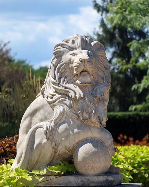 A lion sculpture outdoors amidst greenery at Purdue University Northwest.