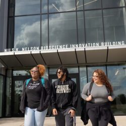 Three students walk together outside of the Nils Bioscience Building