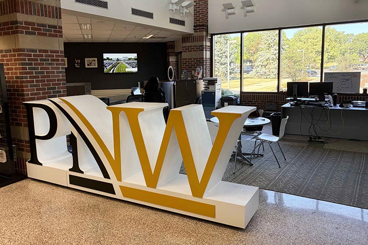 A large standing "PNW" sign in front of a student office