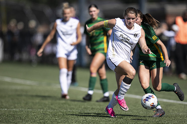 PNW women's soccer players with the ball during a game.