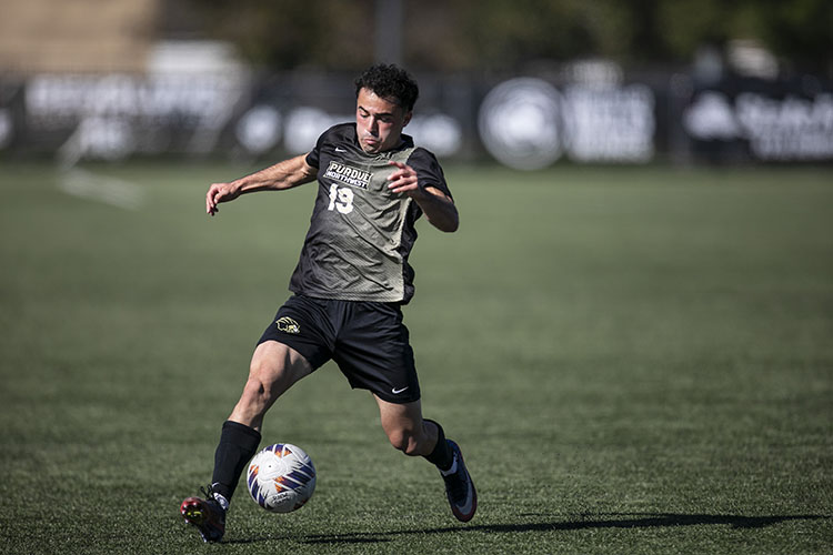 A PNW men's soccer player kicks the ball during a game.
