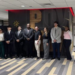 Nine students pose together.