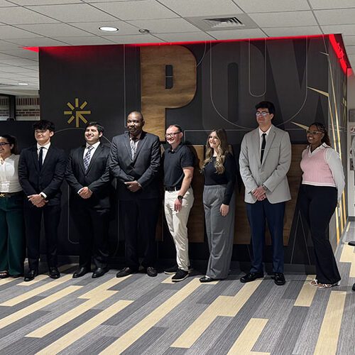 Nine students pose together.