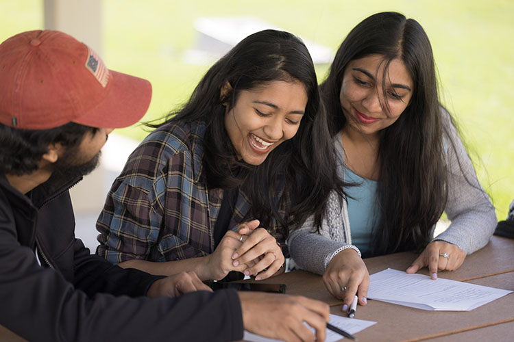 Two students look at a piece of paper.